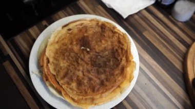 Stack of ruddy pancakes steams on a plate. Top view . High quality 4k footage