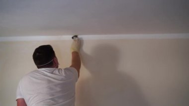 Man in gloves scrubs the mold from the ceiling with a sponge. High quality 4k footage