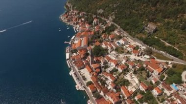 Dağların eteğindeki Perast tatil köyünün antik binalarının kırmızı çatıları. Karadağ. Yüksek kalite 4k görüntü