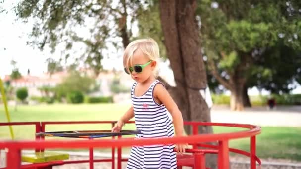 Little Girl Sunglasses Rides Carousel Turning Steering Wheel High Quality — Vídeos de Stock