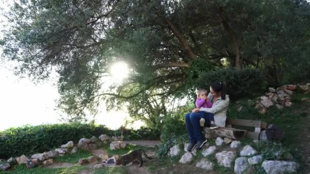 Mom Little Girl Her Knees Sits Bench Cat Garden High — Stockvideo