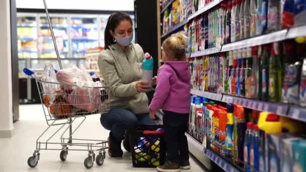 Мама Захисній Масці Вибирає Домашні Хімікати Супермаркеті Маленькою Дівчинкою Кадри — стокове відео