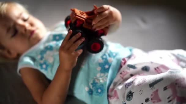 Menina Brincando Com Carro Brinquedo Deitado Cama Imagens Alta Qualidade — Vídeo de Stock