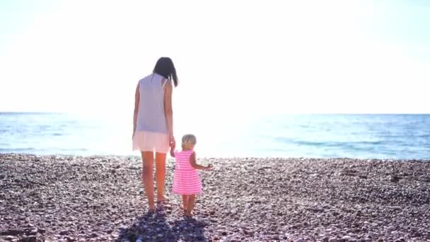 Mom Little Girl Walk Holding Hands Pebble Beach Sea Backdrop — Stock video