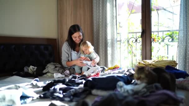 Mamá Con Una Niña Sus Brazos Ordena Ropa Cama Limpia — Vídeo de stock