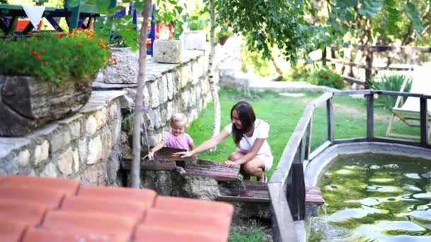 Mom Little Girl Sitting Stream Flows Pond High Quality Footage — Vídeos de Stock