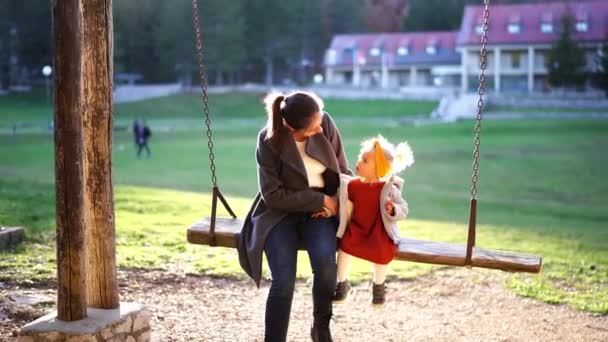 Mamma Con Una Bambina Che Cavalca Altalena Nel Parco Vicino — Video Stock