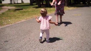 Little girl walks along the road to her mother, who has opened her arms. High quality FullHD footage