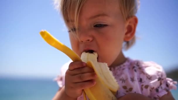 Little Girl Eating Banana Holding Both Hands High Quality Footage — Stockvideo