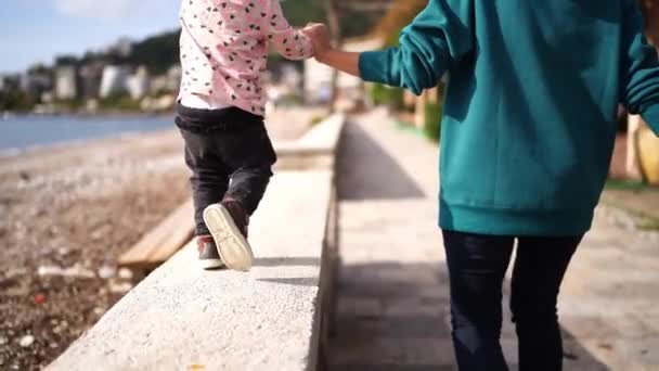 Κοριτσάκι Περπατά Κατά Μήκος Ενός Πέτρινου Φράχτη Κοντά Στην Παραλία — Αρχείο Βίντεο