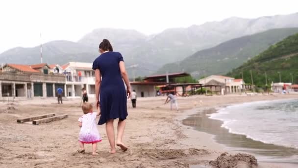 Mamá Una Niña Caminan Por Playa Arena Tomados Mano Vista — Vídeos de Stock