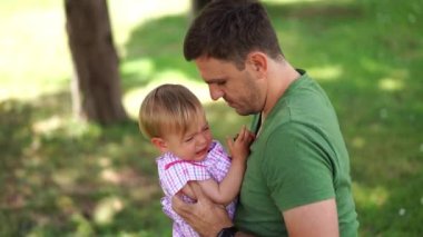 Dad takes pity on the crying little girl, strokes her and wipes her tears. High quality 4k footage