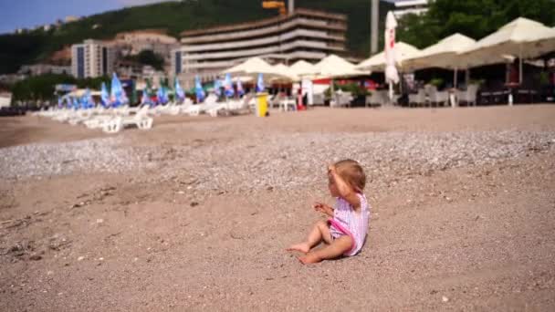小女孩坐在海滩上玩沙子 高质量的4K镜头 — 图库视频影像