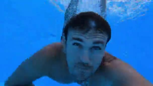 Jongeman Zwemt Onder Water Het Zwembad Bungelend Met Zijn Benen — Stockvideo