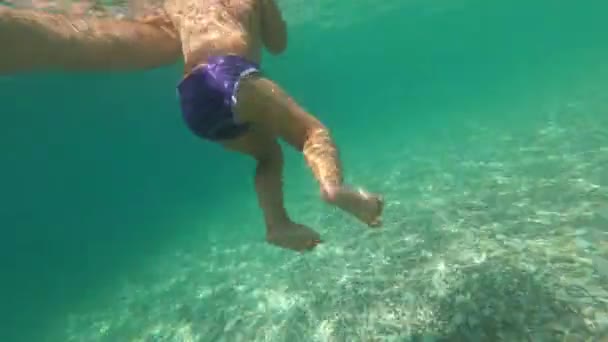 Small Child Floats Sea Dangling His Legs Underwater Supported His — Wideo stockowe