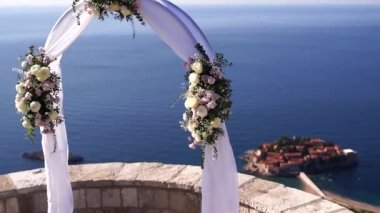 Wedding arch stands on an observation deck overlooking the island of Sveti Stefan. High quality FullHD footage