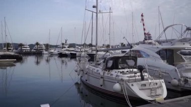 Moored small yachts near the pier against the backdrop of mountains. Porto, Montenegro. High quality FullHD footage