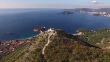 Drone view of the Church of St. Sava on the mountain above the island of Sveti Stefan. High quality 4k footage