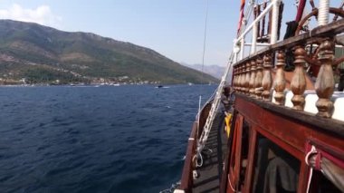 Tahta yelkenli denizde yüzer dağlara doğru. Yüksek kalite 4k görüntü