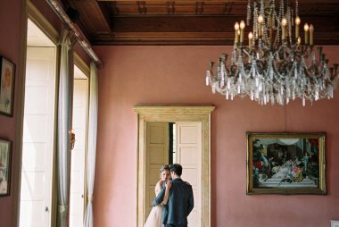 Bride and groom are standing near the door in an old villa. Lake Como, Italy. High quality photo