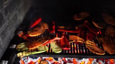 Sliced vegetables are baked on a grate in a brick stove. High quality 4k footage