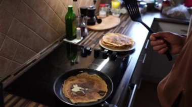 Man with a spatula stands over a pancake being baked in a pan. High quality 4k footage