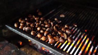 Chestnuts with cracked skins being grilled over a fire. High quality 4k footage