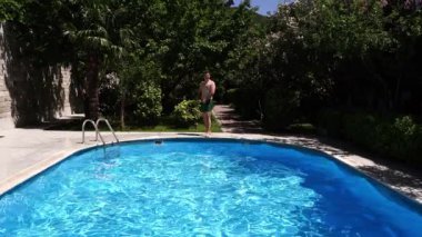 Man dives into the pool and swims underwater. High quality FullHD footage