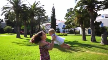 Mom spins around the clearing with a little laughing girl in her arms. High quality FullHD footage