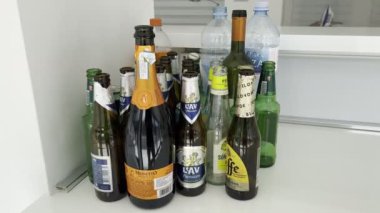 Empty bottles of beer, champagne and water stand on the windowsill. High quality 4k footage