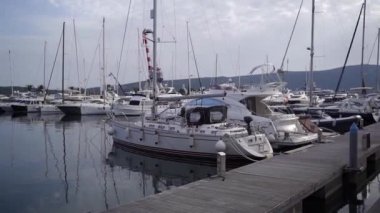 İskeleye demirli yelkenli yatlar, dağların arka planına karşı. Porto, Karadağ. Yüksek kaliteli FullHD görüntüler