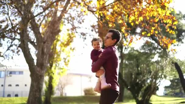 Apa Felrak Egy Kislányt Karjaiba Átöleli Miközben Parkban Áll Kiváló — Stock videók