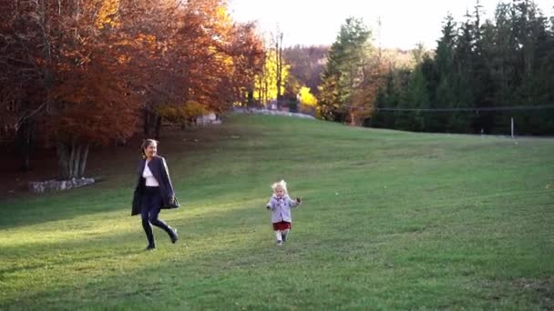 Little Girl Runs Next Her Mother Green Lawn Autumn Park — 图库视频影像