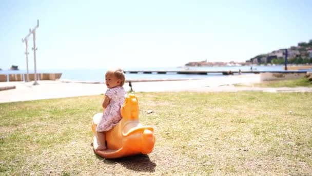 Little Girl Fidgets Bounces Swing Lawn Sea High Quality Fullhd — Wideo stockowe