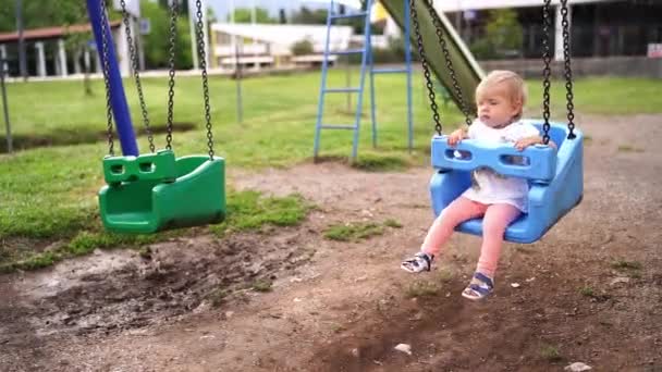 Mała Dziewczynka Huśta Się Huśtawce Trzepie Nogami Placu Zabaw Wysokiej — Wideo stockowe