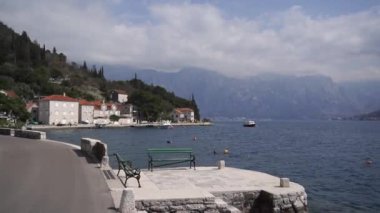 Deniz kıyısındaki taş bir rıhtımda sırtı olan banklar. Yüksek kaliteli FullHD görüntüler