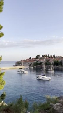Sveti Stefan adası yakınlarında katamaran yelkenlisi. Karadağ. Yüksek kalite 4k görüntü