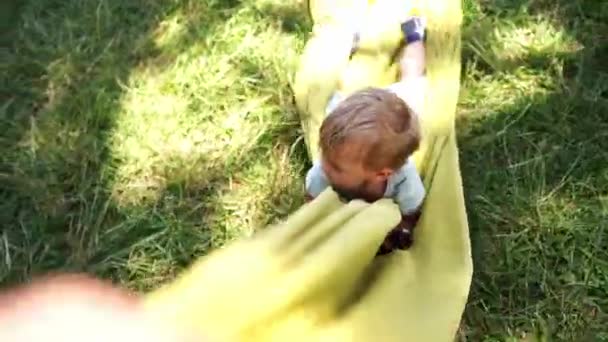 Small Baby Lies Towel Dragged Green Grass High Quality Fullhd — Vídeo de Stock