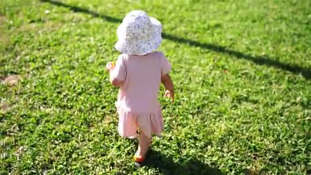 Little Girl Learns Walk Green Lawn Balancing Her Arms High — Stock videók