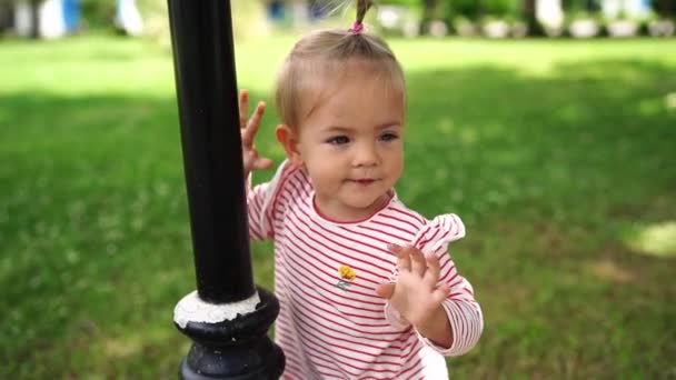 Little Girl Stands Garden Leaning Pole Waving Her Hand High — Vídeos de Stock