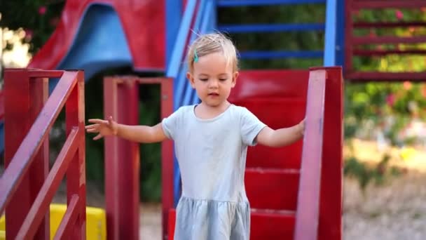 Little Girl Walks Steps Slide Holding Handrails High Quality Footage — Stockvideo