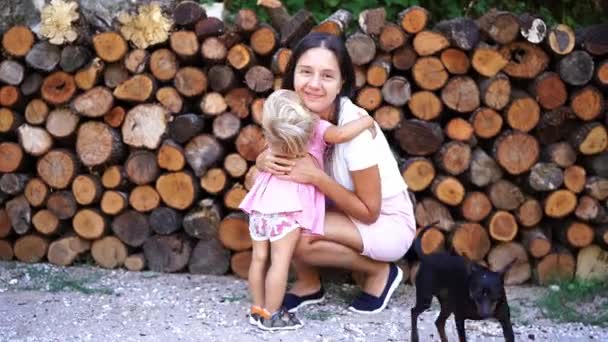 Little Girl Approaches Her Mother Squatting Woodpile Hugs Her High — Stock Video