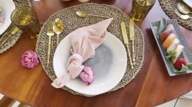 Nigiri set stands next to a plate with a napkin and a flower on it. High quality 4k footage