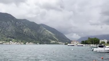 Demirlemiş tekneler yeşil dağların arka planına karşı kıyıya yakın dalgalarda sallanıyor. Yüksek kalite 4k görüntü