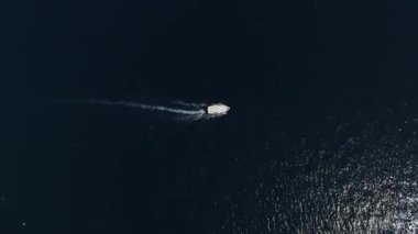 Motorboat floats on the blue sea leaving a white foam trail. Top view. High quality 4k footage