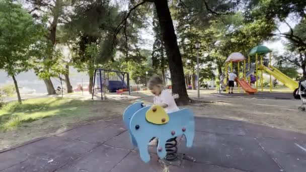 Mała Dziewczynka Huśtawka Wiosennym Huśtawce Placu Zabaw Wysokiej Jakości Materiał — Wideo stockowe