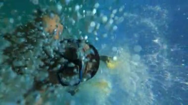 Young man in goggles and flippers swims underwater. High quality 4k footage