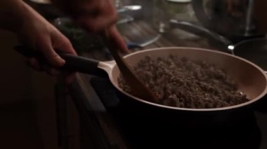 Cook pours oil on the stewing minced meat in a pan and stirs it. High quality 4k footage