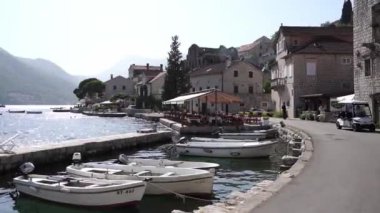 Fishing boats rock on the waves at the Perast Pier. High quality FullHD footage