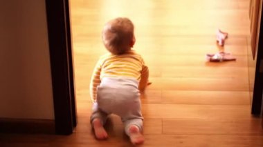 Little baby crawling on the wooden floor in the room. High quality 4k footage
